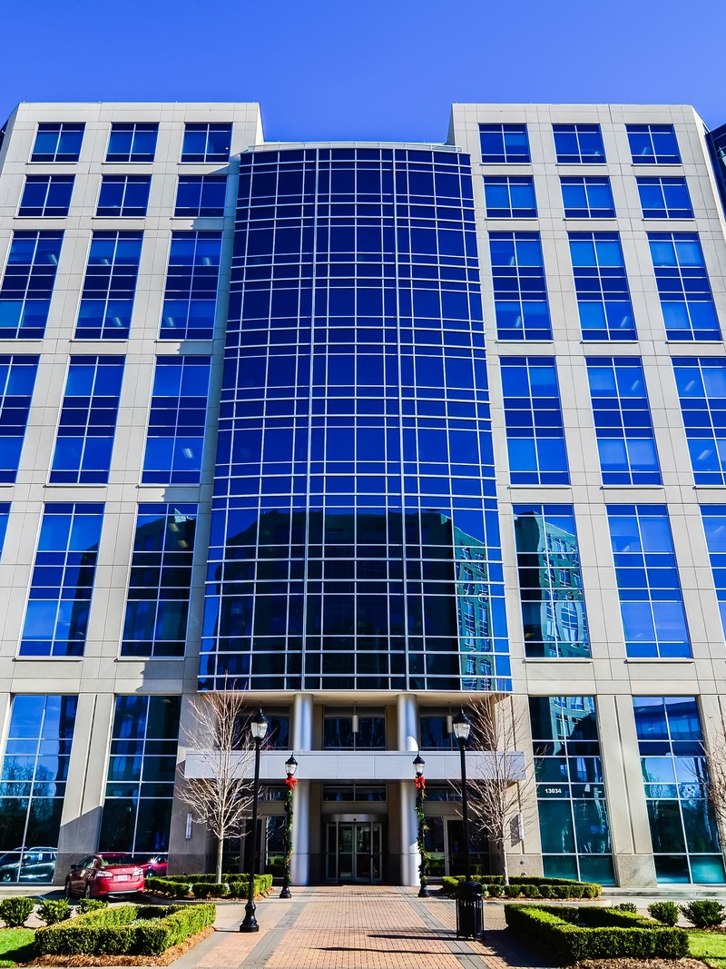 Modern glass office building highlighting a high-yield commercial real estate investment property.